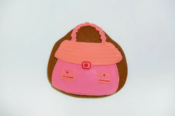 Gingerbread in the form of a woman\'s bag. Confectionery. Sweet pastries. Cookies covered with icing. Cooking Gingerbread cookie on a white background. Gingerbread.
