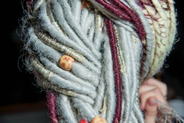 Hafif renkli dreadlocks saç. Saç aksesuarları. Pigtails içinde örgülü dreadlocks. Deldi kulak. Kız. Dreadlocks üzerinde ahşap boncuk. Dred doku.