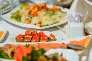 Güzel tablo ayarı düğün. Cam şarap gözlük. Sebze karışımı. Yemekleri masada. Salata tabakları. Meyve. Olay. Beyaz gül buketi. Tartlets kırmızı havyar ile.