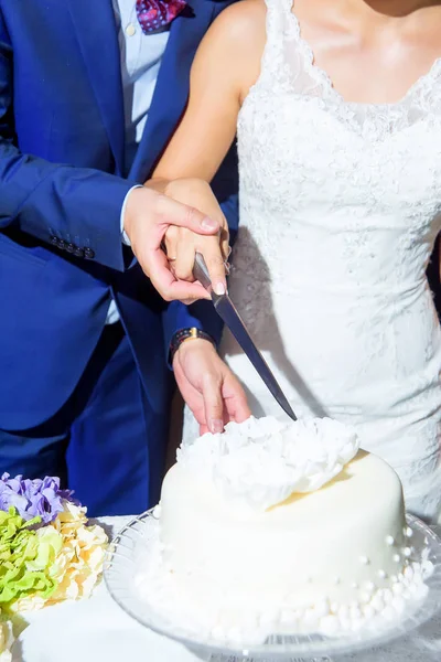 Newlyweds cut the wedding cake. White cake. Dessert. Wedding. Husband and wife. Wedding table decor. Sweet pastries.