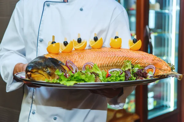 料理は焼き鮭です レタスと皿の上の野菜の葉 魚介類 レモンとオリーブのスライス 魚の料理の料理 料理は 料理を提供しています — ストック写真