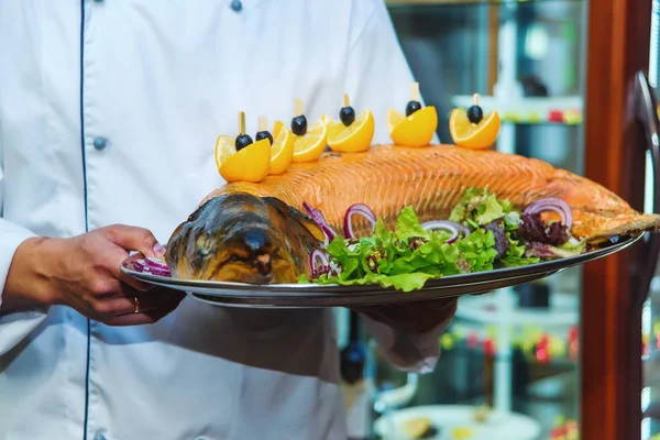 料理は焼き鮭です レタスと皿の上の野菜の葉 魚介類 レモンとオリーブのスライス 魚の料理の料理 料理は 料理を提供しています — ストック写真