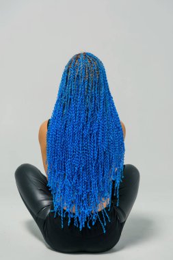 Mavi uzun Zi-Zi pigtails. Örgü dokuma tekniği. Kuaförlük Hizmetleri. Afrokosichki Afrika örgü örgü. Saç modeli. Beyaz bir arka plan üzerinde oturan kız.