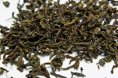 Yaprak çay beyaz bir arka plan üzerinde yatıyor. Yaprak çay depolama. Doğal ürün. Ağırlıklı yeşil çay. Ambalaj ve sıralama. Kuru yaprak dokusu.