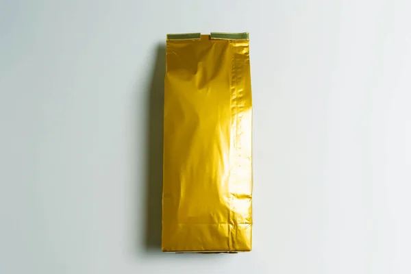 stock image A bag of tea of golden color on a white background. Leaf tea storage. Natural product. Weighted green tea. Packing and sorting.