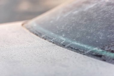 Arabanın kaputuna kırağı. Frost. Açık renk makine. İnce kar katmanı. Kristal frost. Ön cam. Kapıcılar.