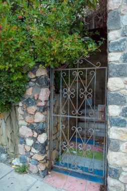 Dövme demir kapısı. Dövme metal kapılar. Sokak duvar dekor taş olduğunu. Dekoratif taş. Yeşil yaprakları ve pembe çiçek tomurcukları ile ağacı. Kaldırım döşeme. Bahçe Dekor.