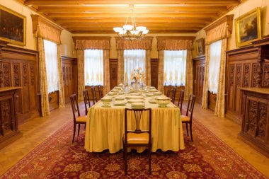 Festival tablo ayarı. Festivaller salonu. Büyük zemin halı. Güzel ahşap oyma. Sanatsal ahşap işleme. Çiçek ve bitkilerin ağaç görüntüler. Ahşap doku.