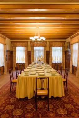 Festival tablo ayarı. Festivaller salonu. Büyük zemin halı. Güzel ahşap oyma. Sanatsal ahşap işleme. Çiçek ve bitkilerin ağaç görüntüler. Ahşap doku.