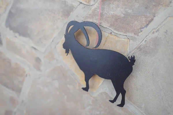 Plastic figure goat. Wall decor under the stone. Decorating the walls of restaurants. Decorative stone in the interior. Restroran. Installation of geometric shapes with yellow illumination.