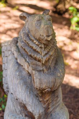 Bir ayı şeklinde ahşap oyma heykel. Bahçe Dekor. Ahşap oyma düşündüm. Doğa. Yeşil bitkiler. Kırım'dinlenme.