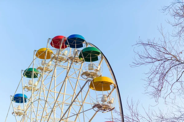 Ferris wheel on the background of blue sky in Crimea. Amusement park. Colored cabins for passengers. Amusement park. Ferris wheel. Metal wheel design.