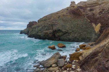 Kayalık sahil deniz kenarında. Karadeniz. Büyük kayalar ve kayalar. Dalgalar gürültüyle çarpmak buzlu. Bir sprey su. Kayalık plaj. Su yüzeyi. Dalgalar. Kırım'dinlenme. Sevastopol. Yolculuk. Turizm.