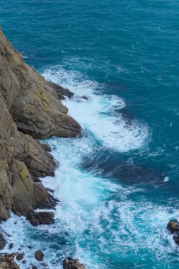 Mavi su. Kayalık sahil. Su yüzey dokusu. Dalgalar kayaların üzerinde yendi. Cliff. Karadeniz. Yün çıkabilir. Yalta. Kırım'dinlenme. Sahil boyunca yürüyerek. Turizm.