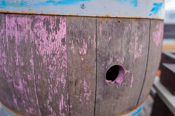The wooden barrel painted in pink color. The vessel is made of cylindrical wood. Barrel. Rubbed paint. Massandra beach. Yalta Rest in Crimea. Walk along the beach.