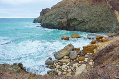 Kayalık sahil deniz kenarında. Karadeniz. Büyük kayalar ve kayalar. Dalgalar gürültüyle çarpmak buzlu. Bir sprey su. Kayalık plaj. Renkli moss buzlu. Kırım'dinlenme. Sevastopol. Yolculuk. Turizm.