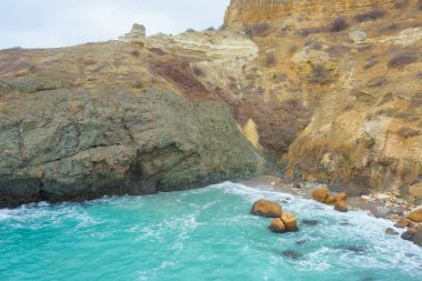 Kayalık sahil deniz kenarında. Karadeniz. Büyük kayalar ve kayalar. Dalgalar gürültüyle çarpmak buzlu. Bir sprey su. Güneşli bir gün. Kırım'dinlenme. Sevastopol. Kıyı yürümek. Yolculuk. Turizm.