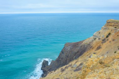 Cape Fiolent. Kayalık sahil. Dalgalar kayaların üzerinde yendi. Karadeniz. Yüzeyi ve su doku. Kırım'dinlenme. Sevastopol. Kırım Dağları. Mavi gökyüzü.