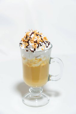Çikolata şurubu ile serpilir krem şanti. Tatlı. Kapuçino krema ile. Gıda fotoğrafçılık. Kahve kremalı. Tatlı kahve beyaz zemin üzerinde bir cam ölçek.