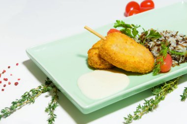 Çok renkli pirinç şeklinde bir garnitür ile tavuk pirzola. Kiraz domates. Taze maydanoz yaprakları. Gıda fotoğrafçılık. Akşam yemeği. Et yemek bir ışık mavi plaka.