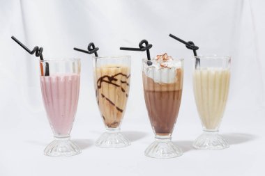 Milkshake cam bardak. Süt-karamel kokteyl ile bir kaşık dondurma. Çilekli kokteyl. Kahve krem şanti ile kokteyl. Gıda Fotoğrafçılık. Hisse senedi kokteyller.