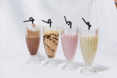 Milkshake cam bardak. Süt-karamel kokteyl ile bir kaşık dondurma. Çilekli kokteyl. Kahve krem şanti ile kokteyl. Gıda Fotoğrafçılık. Hisse senedi kokteyller.