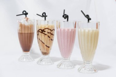 Milkshake cam bardak. Süt-karamel kokteyl ile bir kaşık dondurma. Çilekli kokteyl. Kahve krem şanti ile kokteyl. Gıda Fotoğrafçılık. Hisse senedi kokteyller.