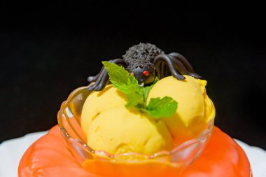 Meyve portakal jöle. Sarı dondurma topları. Çikolata örümcek tatlı tatlı. Nane taze yeşil yaprak. Bir parça kek. Güzel tatlı hizmet. Cadılar Bayramı menüsü.