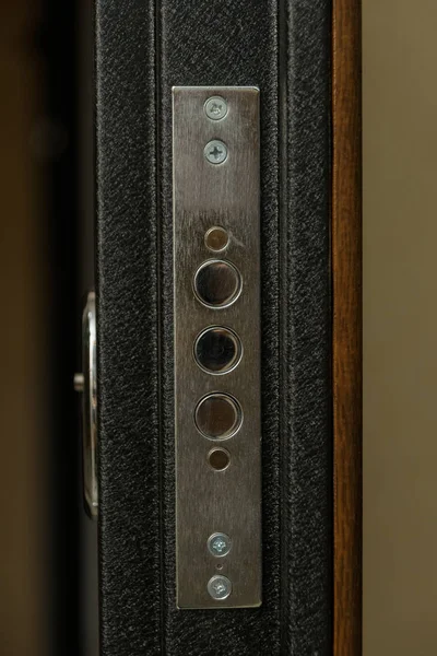 The door is sheathed in wood. Wood carving. Internal lock design. Keyhole. Metal door handle. Anti-burglar armored door. Metal doors. The design of the door. Peephole.