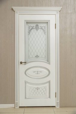 Kapı beyaz boyalı. Ahşap oyma. Metal kapı kolu. Anti-hırsız zırhlı kapı. Metal iç kapılar. Kapı tasarımı. İç.