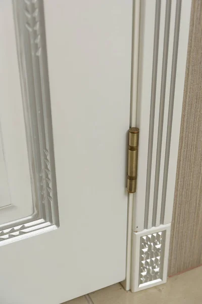 Door painted white. Wood carving. Metal door handle. Anti-burglar armored door. Metal interior doors. The design of the door. Interior.