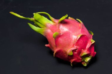 Egzotik meyve. Dragon meyve. Kırmızı pitaya. Tatlı pitahaya siyah bir arka plan. Dragon meyve kesme. Meyve yüzeyinde doku. Ejder Gözü.