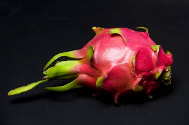 Egzotik meyve. Dragon meyve. Kırmızı pitaya. Tatlı pitahaya siyah bir arka plan. Dragon meyve kesme. Meyve yüzeyinde doku. Ejder Gözü.