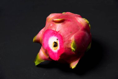 Egzotik meyve. Dragon meyve. Kırmızı pitaya. Tatlı pitahaya siyah bir arka plan. Dragon meyve kesme. Meyve yüzeyinde doku. Ejder Gözü.