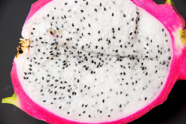 Exotic fruit. Dragon fruit. Red pitaya. Pitahaya pulp with black seeds. Sweet pitaya on white background. Cut dragon fruit. Pitaya with white flesh.