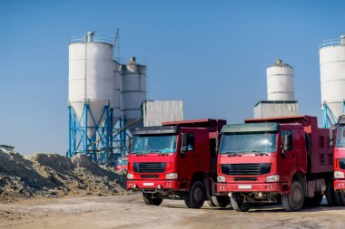 Damperli kamyon çimento olarak yüklenmemesi. Sanayi. Çimento fabrikası. Çimento üretim. Kargo kendini boşaltma araba kırmızı. Ulaşım çimento. Kırmızı Damperli kamyonlar.