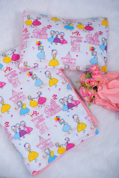 Pillow for the newborn. Blanket and pillow for newborns. The texture of the fabric. Pillows bumpers. The sides of the pillow in the crib. Bouquet of roses. Princess print on fabric.