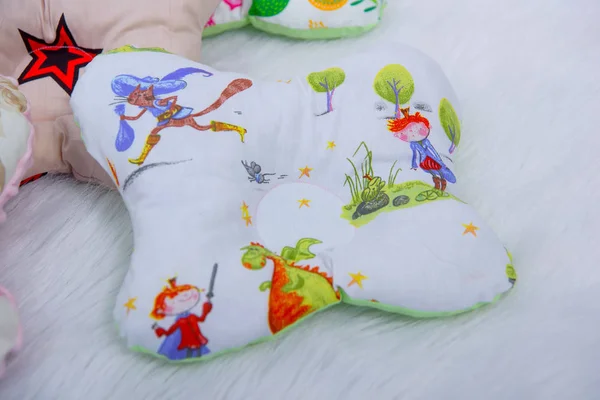 Orthopedic pillows for newborns. Pillows bumpers. Set of pillows for a baby cot. The texture of the fabric. Print with animals and plants. The sides of the pillow in the crib. Orthopedic pillow.