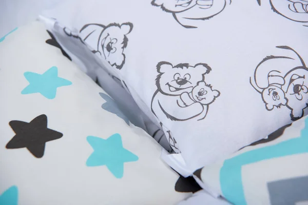 Pillows for newborns. Pillows bumpers. Set of pillows for a baby cot. The texture of the fabric. Print with bears and stars. The sides of the pillow in the crib.