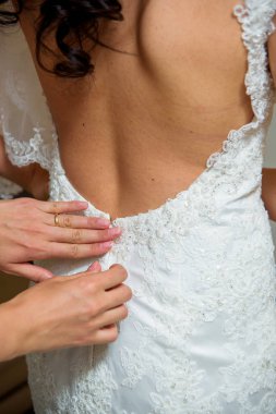 Düğün töreni. Gelin düğün için hazırlanıyor. Beyaz gelinlik. Korse elbise. Kumaş dokusu. Beyaz dantel kumaş. Küpe. Dantel jartiyer bacak. Gelin jartiyer.