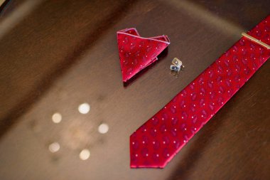 Düğün töreni. Damat Düğün için hazırlanıyor. Kravat ve kol düğmeleri. Deri pantolon kemer. Beyaz gömlekli bir adam. Kırmızı kravat. Erkek Ayakkabı siyah.