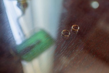 Altın nişan yüzük. Takı. Düğün töreni. Düğün. Ahşap bir masaya alyans vardır.