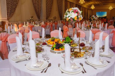 Düğün masa hizmet. Dekorasyon taze çiçekler ile festival tablo. Buket çiçek masanın üzerinde. Taze çiçekler. Meyve tabakları. Yay ile dekore edilmiş koltukları.