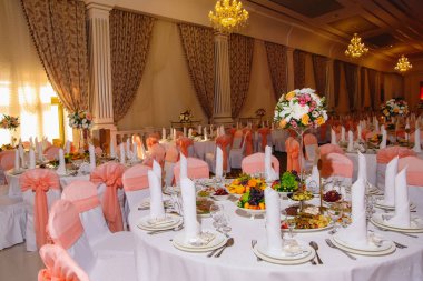 Düğün masa hizmet. Dekorasyon taze çiçekler ile festival tablo. Buket çiçek masanın üzerinde. Taze çiçekler. Meyve tabakları. Yay ile dekore edilmiş koltukları.