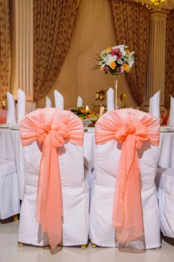 Düğün masa hizmet. Dekorasyon taze çiçekler ile festival tablo. Buket çiçek masanın üzerinde. Taze çiçekler. Meyve tabakları. Yay ile dekore edilmiş koltukları.