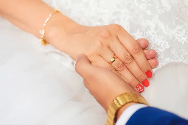 丈夫和妻子的手 白色婚纱结婚戒指手镯和金表 美甲配红色清漆 — 图库照片