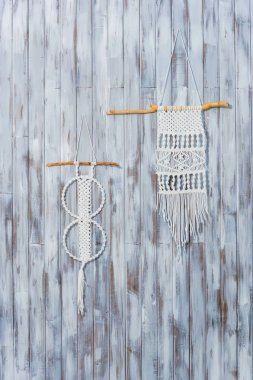 Ahşap duvardaki macrame. El yapımı beyaz iplik dekor. Rustik tarzda bir ev dekorasyon.