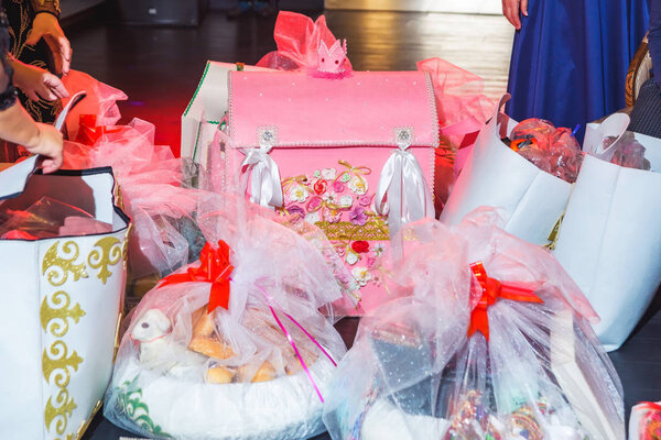 Decorative pink cardboard house with a crown. Gifts Packed in transparent paper with red ribbon. The event at the restaurant.