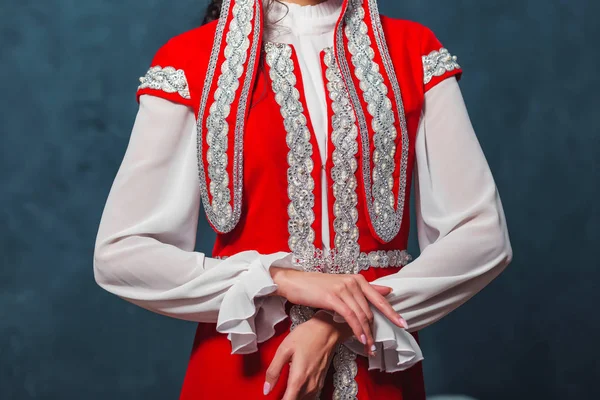 哈萨克斯坦国家婚纱 女孩的手织物上的装饰品和刺绣 这堵墙是蓝色的 红色的裙子哈萨克新娘的传统服饰 — 图库照片