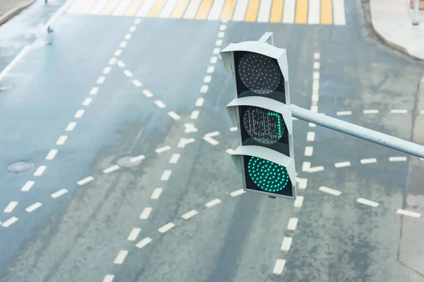 Green traffic light. Modern traffic lights with a timer. Road traffic in the big city. Road markings at a regulated intersection. Pedestrian crossing in the metropolis